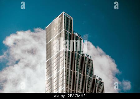 Alto edificio a torre davanti ad un cielo blu e nuvole, edificio di appartamenti, appartamenti, architettura moderna nello skyline della città Foto Stock