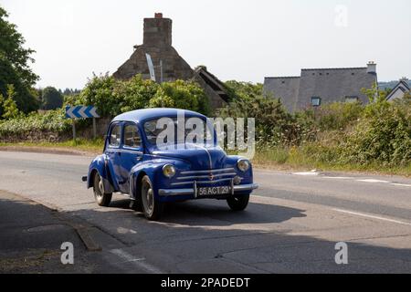 Kerlaz, Francia - Luglio 17 2022: Uomo in pensione in crociera in una Renault 4CV blu. Foto Stock