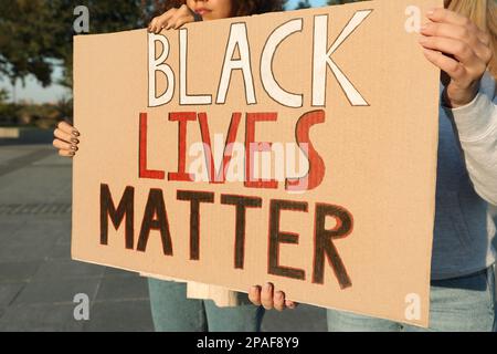 Le donne che tengono il segno con la frase Black Lives contano all'aperto, primo piano. Concetto di razzismo Foto Stock