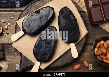 Deliziose gelaterie glassate, cioccolato e noci su tavola di legno, piatto Foto Stock