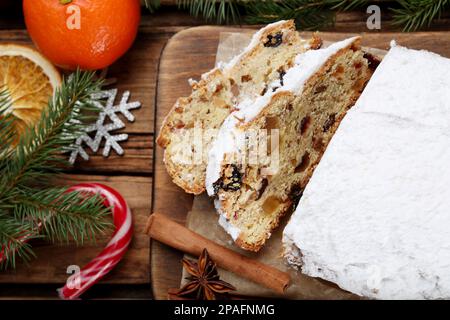 Tradizionale stollen di Natale con zucchero a velo su tavola di legno, piatto Foto Stock