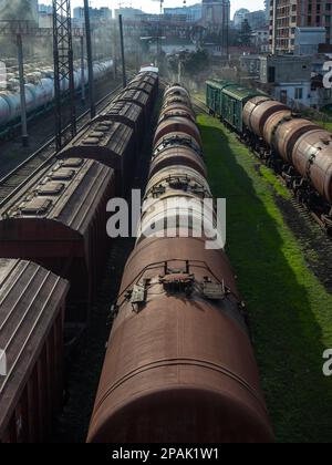 Batumi, Georgia. 02.25.2023 Area di carico della stazione. Molti treni merci. Carri - carri su rotaie. Esportazione di carburante. Fumo nella zona industriale Foto Stock