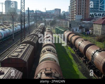 Batumi, Georgia. 02.25.2023 Area di carico della stazione. Molti treni merci. Carri - carri su rotaie. Esportazione di carburante. Fumo nella zona industriale Foto Stock