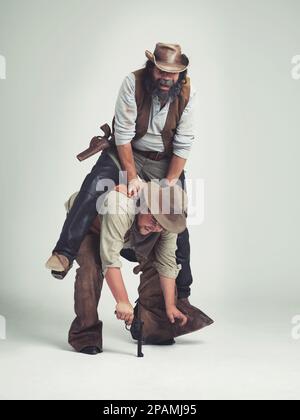 Di che cosa si tratta esattamente questa immagine. Le cose strane accadono quando Yuri sta sparando roba....colpo corto di un cowboy che prova a arrampicarsi sui suoi soci indietro Foto Stock