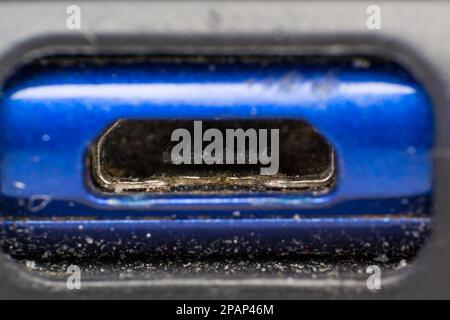 primo piano con la polvere proveniente dalla ricarica micro usb di un telefono Foto Stock
