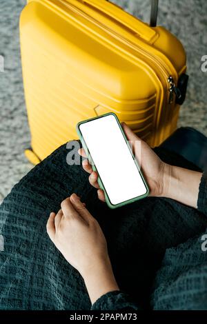 Uso del telefono in viaggio. Smartphone con schermo vuoto in aeroporto prima del volo. Applicazione per viaggi, servizi bancari, concetto. Foto di alta qualità Foto Stock