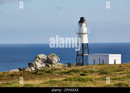 Isole di Scilly, Regno Unito - Faro di Peninnis in una soleggiata giornata autunnale con rocce, mare e erba Foto Stock