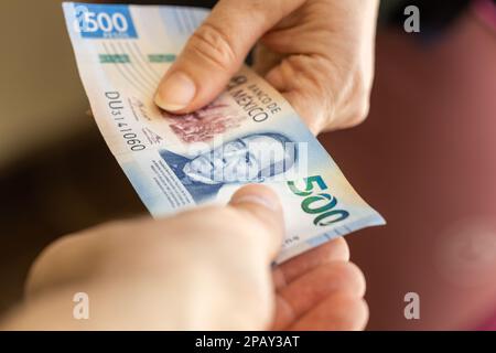 Messico 500 pesos, trasferimento di denaro da mano a mano, concetto di business finanziario, valuta messicana Foto Stock