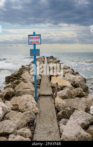 Diga di acqua frangiflutti sulla spiaggia di Lido di Venezia a Venezia, Italia con segno di lettura Vietato Salire sulla Digi - è vietato salire sulla diga Foto Stock