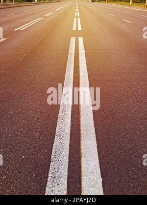 Doppie linee bianche sulla strada asfaltata al centro. doppia linea tratteggiata sulla strada Foto Stock