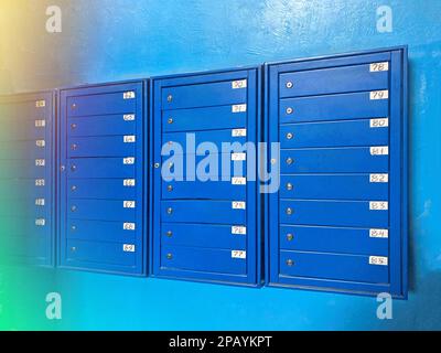 Sfondo di file di cassette postali numerate in moderni appartamenti residenziali con sfondo svasato. Sfondo di caselle postali blu in un appartamento residenziale Foto Stock