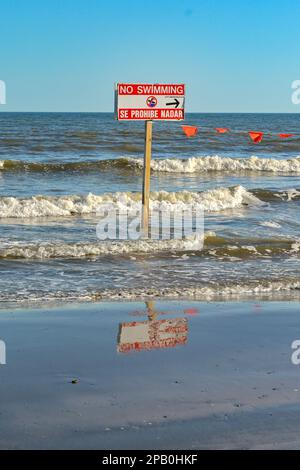 Galveston, Texas, USA - 2023 febbraio: Segnale di avvertimento sul bordo dell'acqua che dice ai visitatori che non c'è nuoto per motivi di sicurezza Foto Stock