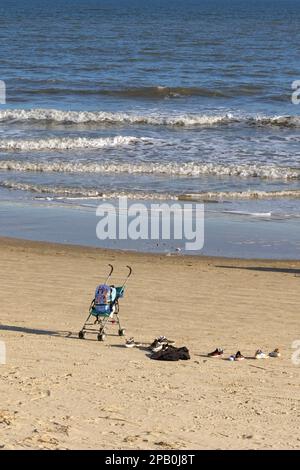 Galveston, Texas, USA - 2023 febbraio: Scarpe e passeggino con zaino lasciati incustoditi in spiaggia da una famiglia Foto Stock