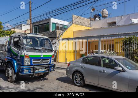 Guadalajara, Jalisco Messico. Dicembre 27, 2022. Fornitura di gas propano, gas autocisterna camion parcheggiato di fronte a una casa residenziale contro un cielo blu in b Foto Stock