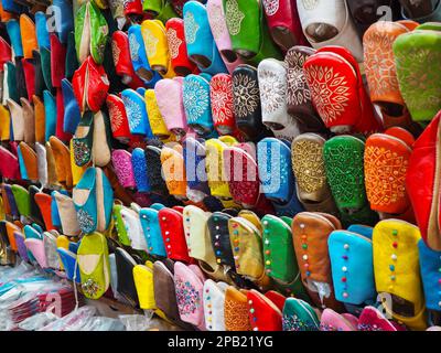Babouche colorata fatta a mano - pantofole in pelle in mostra al souk tradizionale - mercato di strada in Marocco Foto Stock