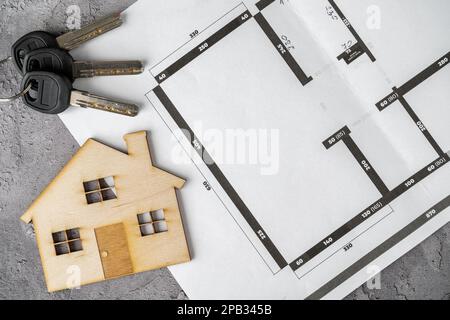 Piani casa o progetto di costruzione BluePrint, casa modello in legno e chiavi. Architetto, designer d'interni o concetto di agente immobiliare. Foto Stock