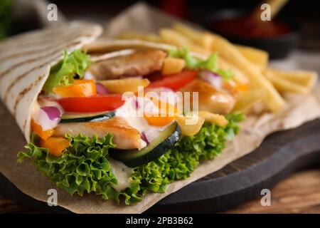 Delizioso shawarma di pollo su tavolo di legno, primo piano Foto Stock