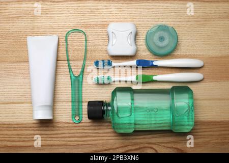 Composizione piana con detergente per lingua e prodotti per la cura dei denti su tavolo in legno Foto Stock