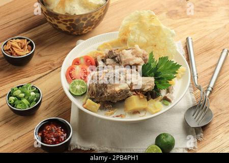 Soto Betawi, tradizionale zuppa di costolette di manzo di Betawi, Giacarta. La zuppa di latte di mucca e cocco, contiene patate, pomodoro e servita con EMPI Foto Stock