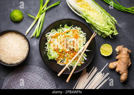 Insalata vietnamita. Ingredienti freschi per la cena vietnamita: Carta di riso, riso, tagliatelle, cipolla verde, cavolo di napa, insalata. Ingredienti per la cucina asiatica Foto Stock