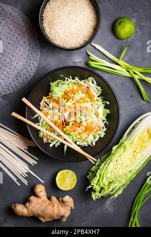 Insalata vietnamita. Ingredienti freschi per la cena vietnamita: Carta di riso, riso, tagliatelle, cipolla verde, cavolo di napa, insalata. Ingredienti per la cucina asiatica Foto Stock