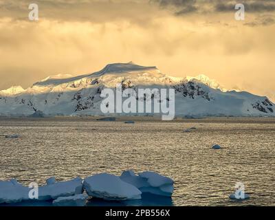 Tramonto a Portal Point Antartide contro le montagne innevate Foto Stock