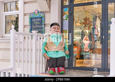 Kazan, Russia - 12 gennaio 2023: Ingresso al negozio di souvenir nell'area turistica. Cucciolo a grandezza naturale del nonno tataro in abiti nazionali. Vecchio Tatar sett Foto Stock