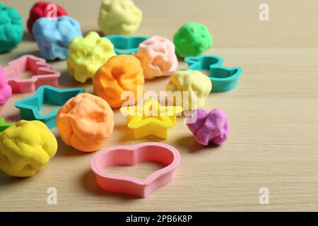 Pasta di colore diverso gioco con stampi su tavolo di legno Foto Stock