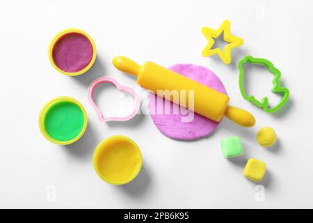 Set di strumenti e pasta color play su sfondo bianco, vista dall'alto Foto Stock