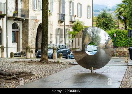 BERGAMO, ITALIA - APRILE 2022: Città di Bergamo riflessa in una superficie speculare dell'oggetto d'arte moderna di Bergamo. Esplora Città Alter, il quartiere dell'alta città Foto Stock