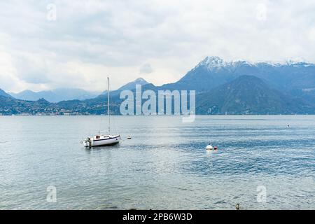 Piccolo yacht attraccato nel porto turistico di Varenna, una delle città più pittoresche sulla riva del lago di Como. Varenna, Lombardia, Italia. Foto Stock