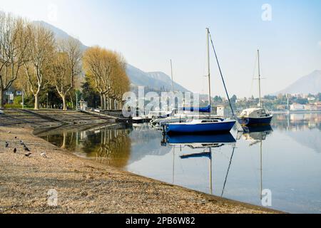 Colorati yacht attraccati al porto turistico della città di Lecco il giorno di primavera. Pittoresco lungomare di Lecco situato tra il famoso Lago di Como e la scenografica Bergamo Alp Foto Stock