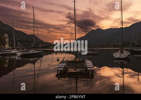 Colorati yacht attraccati al porto turistico della città di Lecco al tramonto primaverile. Pittoresco lungomare di Lecco situato tra il famoso Lago di Como e la scenografica Bergamo Foto Stock