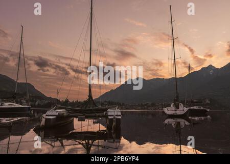 Colorati yacht attraccati al porto turistico della città di Lecco al tramonto primaverile. Pittoresco lungomare di Lecco situato tra il famoso Lago di Como e la scenografica Bergamo Foto Stock