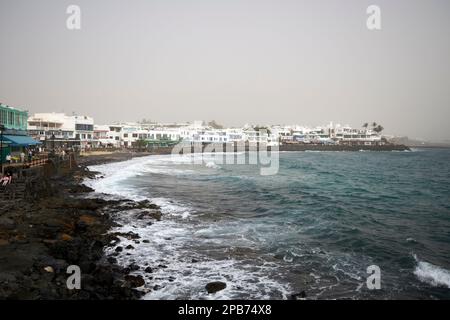 Playa blanca lungomare coperto di densa polvere sabbiosa soffiata dal sahara dal vento calima Lanzarote, Isole Canarie, Spagna Foto Stock