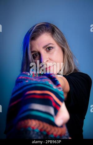 Bella donna con sciarpa colorata. Isolato su sfondo grigio. Foto Stock