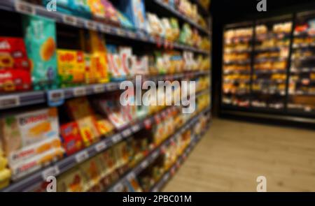 Immagine sfocata degli scaffali con spuntini nel supermercato. Foto Stock