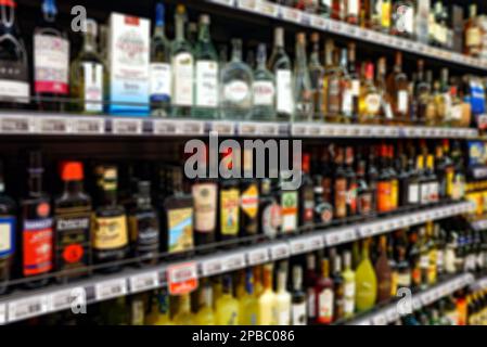 Immagine sfocata di ripiani con bevande alcoliche nel supermercato. Foto Stock