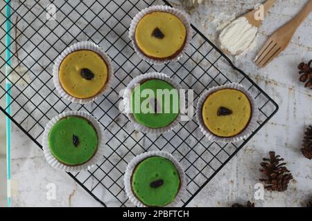 KUE Kuala Lumpur o torta di fango, una tradizionale torta indonesiana fatta di patate, farina, uova e latte di cocco con una spruzzata di uva passa servita su una griglia per torte. Foto Stock