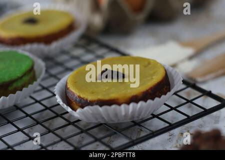 KUE Kuala Lumpur o torta di fango, una tradizionale torta indonesiana fatta di patate, farina, uova e latte di cocco con una spruzzata di uva passa servita su una griglia per torte. Foto Stock