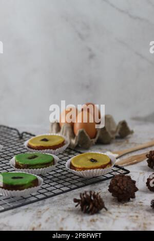 KUE Kuala Lumpur o torta di fango, una tradizionale torta indonesiana fatta di patate, farina, uova e latte di cocco con una spruzzata di uva passa servita su una griglia per torte. Foto Stock