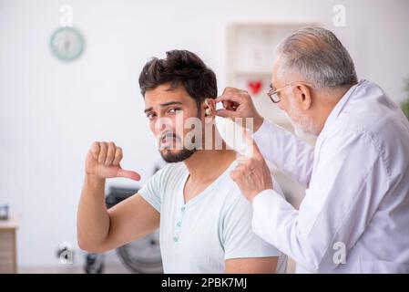 Giovane paziente con problemi di udito visita dottore otorinolaringologo Foto Stock
