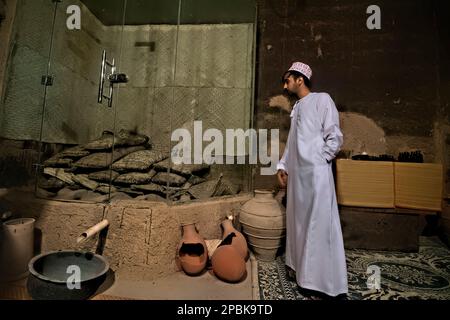 Uomo che indossa il tradizionale abito da dishasha, Bait al Safah, al Hamra, Oman Foto Stock