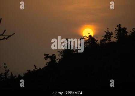 Splendida vista sull'alba. Nuvole da un lato e il sole che sorge sulle montagne dall'altro. Regione collinare del Bangladesh. Foto scattata da Meghbari, Foto Stock
