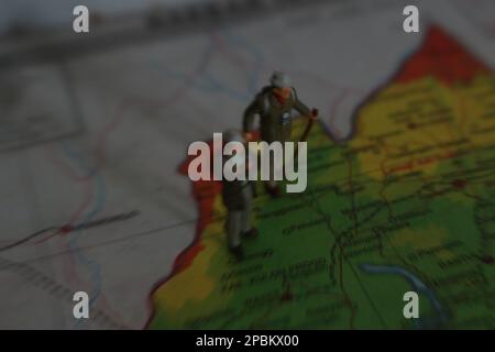 figura in miniatura di un esploratore in posa su una mappa o un atlante Foto Stock