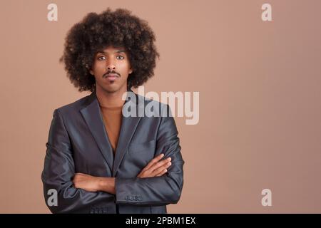 Uomo africano serio ed elegante che indossa una giacca guardando la fotocamera Foto Stock