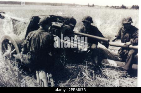 Seconda guerra mondiale foto B&N soldati tedeschi caricano una pistola anticarro Pak40 75mm. Gli uomini vestiti di camouflage Smocks provengono dal 5th SS Panzer Division Wiking Foto Stock