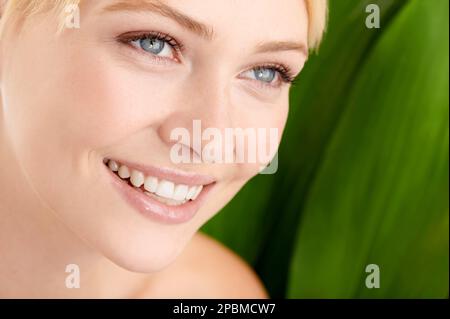 Natura e bellezza naturale. Primo piano di una bella giovane donna in piedi su uno sfondo verde. Foto Stock