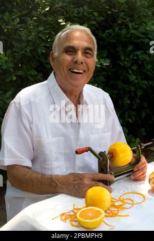 UOMO CUBANO ANZIANO CHE SBUCCIA LE ARANCE MIAMI FLORIDA USA Foto Stock