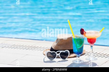 Due colorati bicchieri da cocktail ai bordi della piscina. Con spazio per la copia Foto Stock